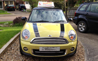 Driving lessons in yellow mini cooper instruction car